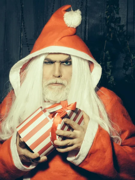 Ernsthafter Weihnachtsmann mit Geschenk — Stockfoto