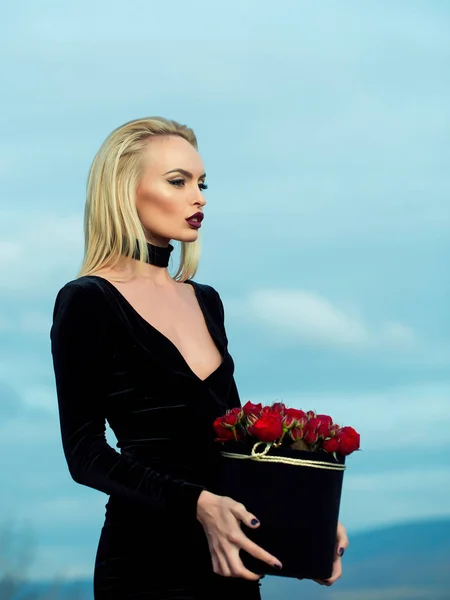 Menina bonita com flores na caixa — Fotografia de Stock