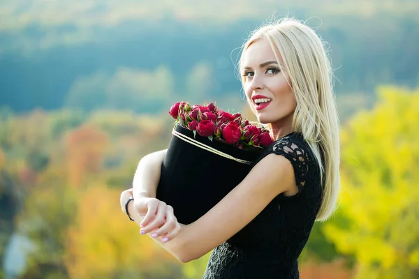 Pretty girl with flowers in box — Stock Photo, Image