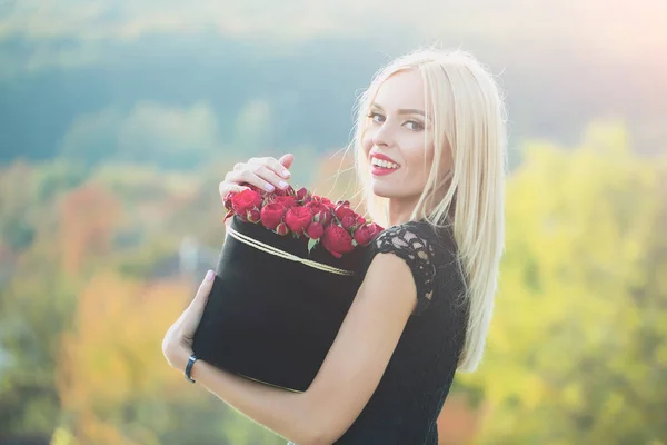 Mooi meisje met bloemen in doos — Stockfoto