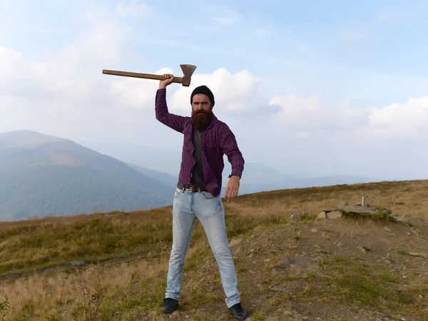 Hombre barbudo con hacha en la montaña — Foto de Stock