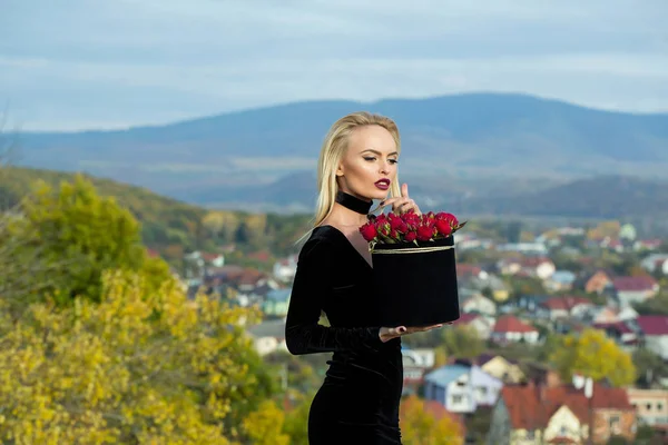 Красивая девушка с цветами в коробке — стоковое фото