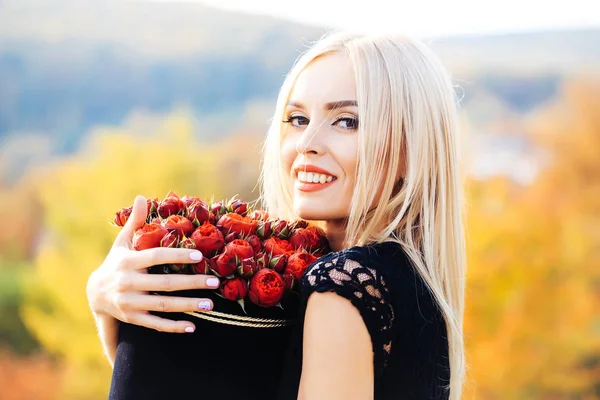 Hübsches Mädchen mit Blumen im Karton — Stockfoto