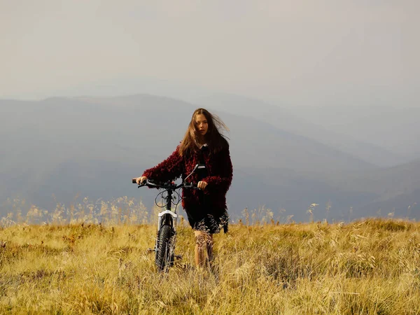 Meisje met fiets op berg — Stockfoto