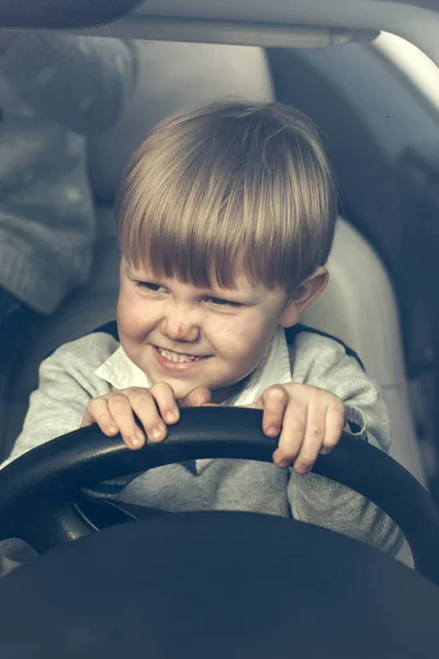 Милый мальчик притворяется, что водит машину — стоковое фото