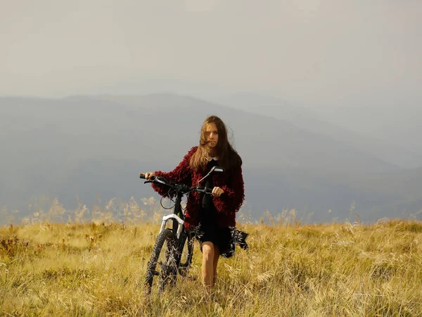 Chica con bicicleta en la montaña — Foto de Stock