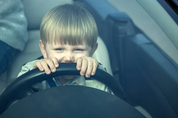 Cute boy pretends driving car — Stock Photo, Image