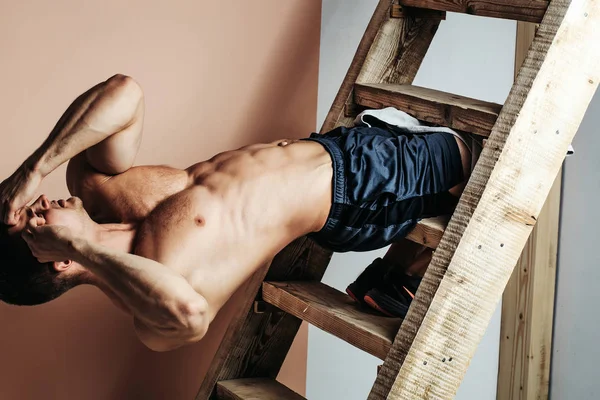 Sexy hombre muscular atleta en escalera — Foto de Stock