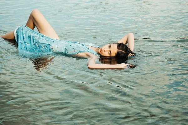 Vacker flicka ligger i vatten — Stockfoto