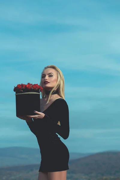 Jolie fille avec des fleurs en boîte — Photo