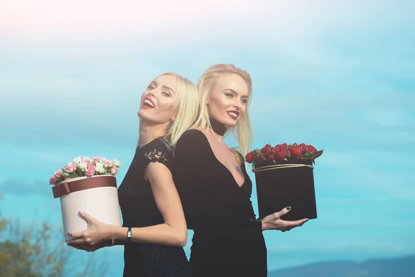 Chicas bonitas con flores en caja — Foto de Stock