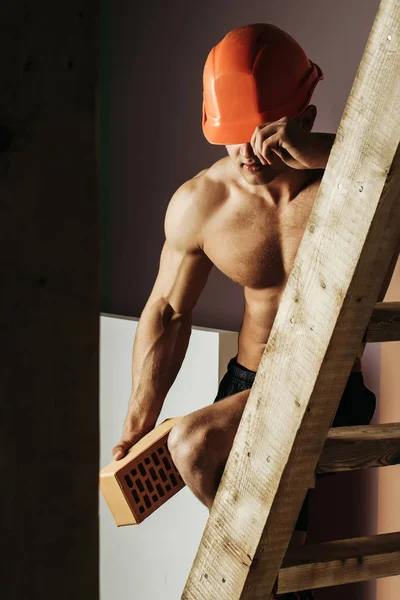 Sexy gespierde man bouwer op de ladder — Stockfoto