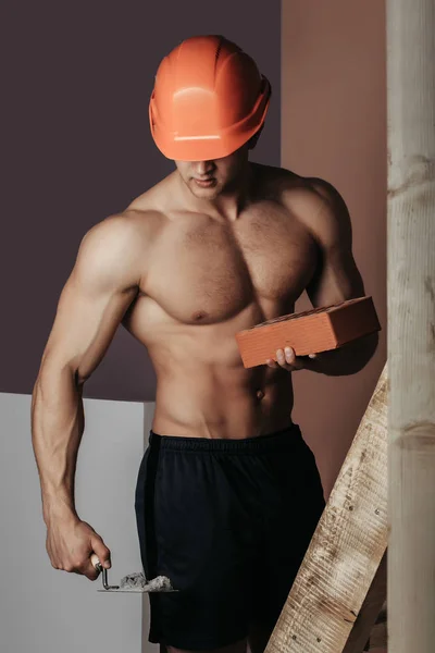 Sexy gespierde man bouwer op de ladder — Stockfoto