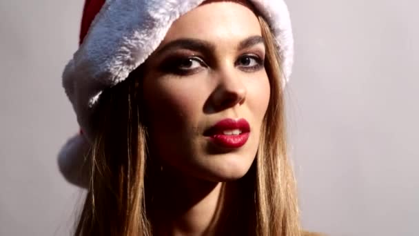 Gros plan d'une fille en bonnet Santas et maquillage festif — Video