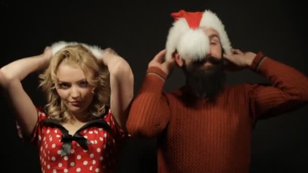 Девушка и мужчина надевают рождественские шляпы — стоковое видео