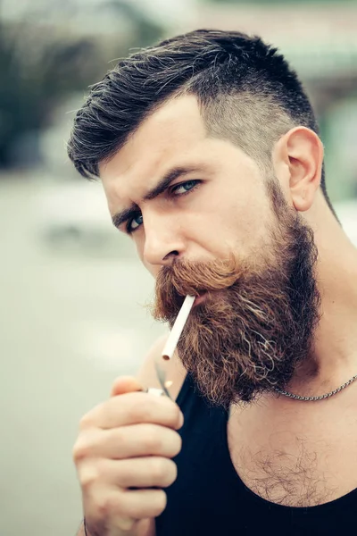 Hombre barbudo enciende cigarrillo — Foto de Stock