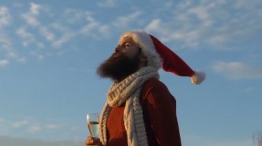 Gökyüzü arka plan üzerinde dalga geçmeyi Noel Baba kılığında adam