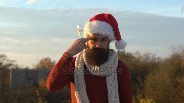 Kerstman met champagne glas raakt zijn wenkbrauw en kijken naar de camera — Stockvideo