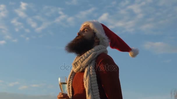 Człowiek w stroju Świętego Mikołaja, wygłupiać się na tle nieba — Wideo stockowe