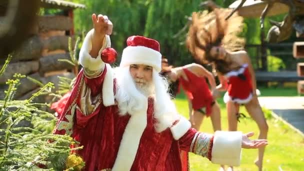 Santa z zabawek na choinkę i dwie sexy Maiden śniegu z długimi włosami w tle — Wideo stockowe