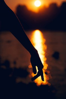 Güzel gün batımı üzerinde el