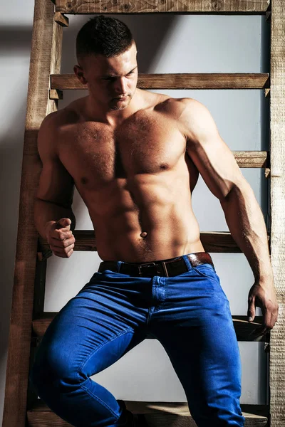 Sexy muscular man athlete at ladder — Stock Photo, Image