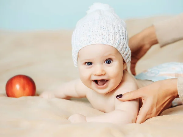 Baby boy in white hat and with red apple — Stock Photo, Image