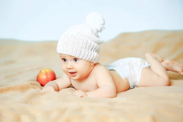 Liten pojke i vit hatt med apple — Stockfoto