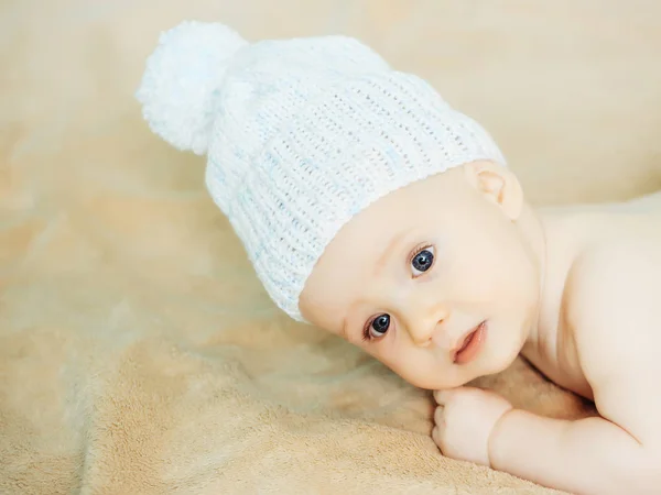 Malý chlapeček v bílém klobouku na dece — Stock fotografie