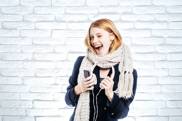 Kulaklýklý mikrofon seti ve telefon ile gülümseyen kız — Stok fotoğraf