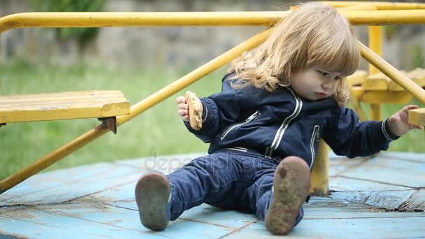 Грустный ребенок плачет и играет на детской площадке — стоковое видео