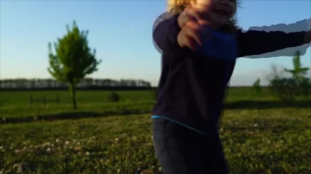 Niño sentado en la hierba en el campo — Vídeos de Stock