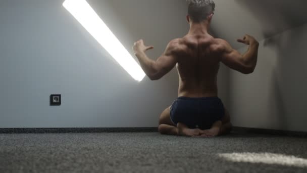 Jonge bodybuilder atleet treinen spieren close-up in de zolderkamer — Stockvideo