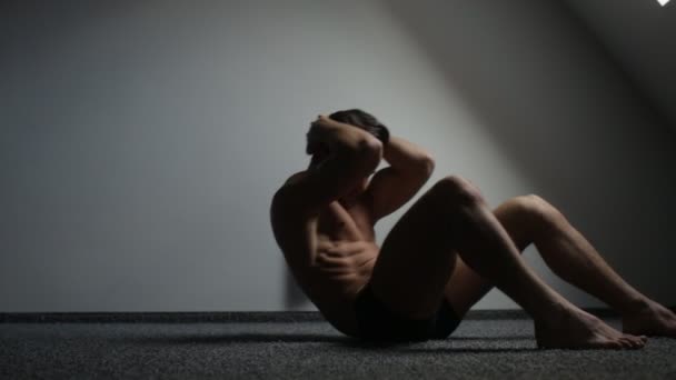 Junger Mann macht Sit-Ups, übt zu Hause — Stockvideo