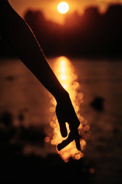 Güzel gün batımı üzerinde el