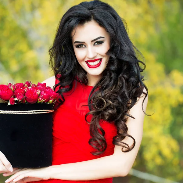 Sexiga leende flicka med röda rosor — Stockfoto