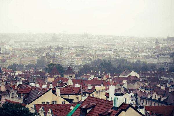 Old town or city roofs with terracotta tiles medieval houses buildings palaces cathedral landmarks on foggy sky