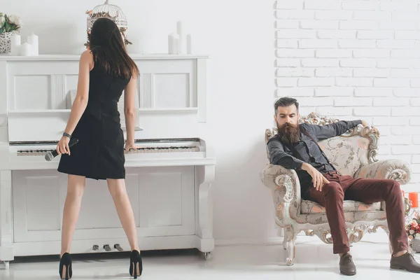 Девушка играет на пианино, а мужчина слушает — стоковое фото