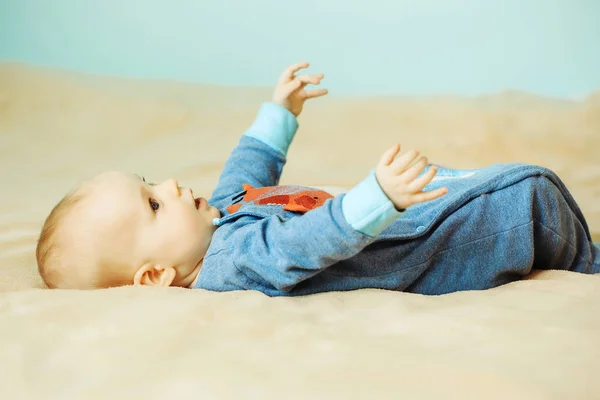 Маленький симпатичный веселый ребенок на кровати — стоковое фото