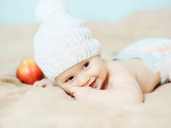 Kleiner Junge mit weißem Hut und Apfel — Stockfoto