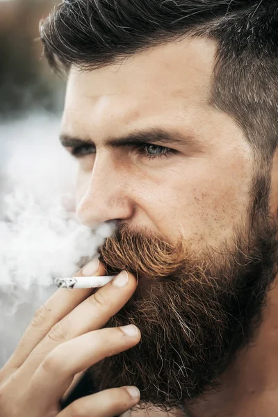 Homem de barba franzido fumando cigarro — Fotografia de Stock