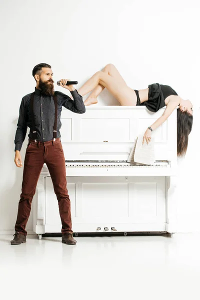 Пара с микрофоном и фортепиано — стоковое фото