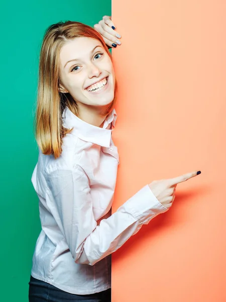 Smiling girl points with finger