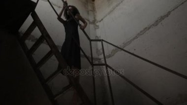 Kız yavaşça eski merdivenlerden tırmanıyor