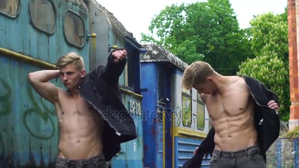 Unga manliga tvillingar med sexig kropp visar sin muskulösa överkropp och abs — Stockvideo