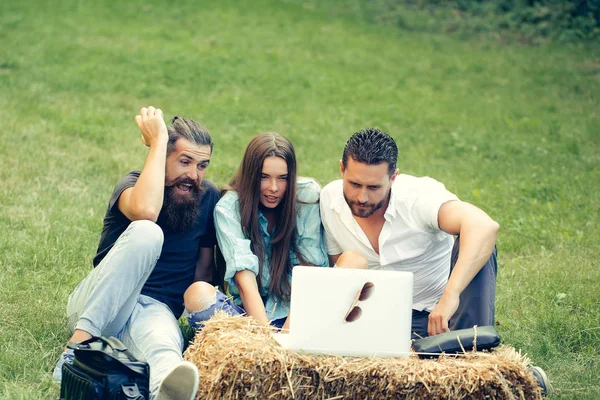 Cheerful friends use laptop computer — Stock Photo, Image