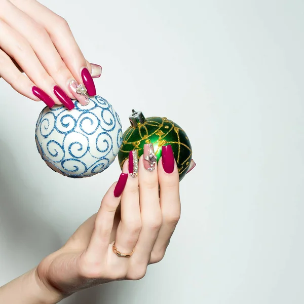 Mãos femininas segurar bugigangas de Natal — Fotografia de Stock