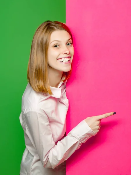 Smiling girl points with finger — Stock Photo, Image