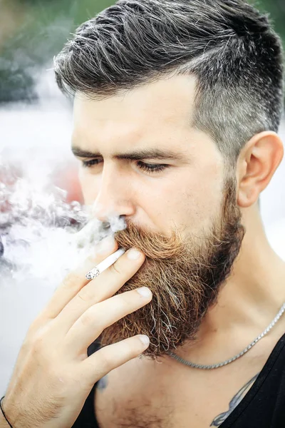 Homem de barba franzido fumando cigarro — Fotografia de Stock