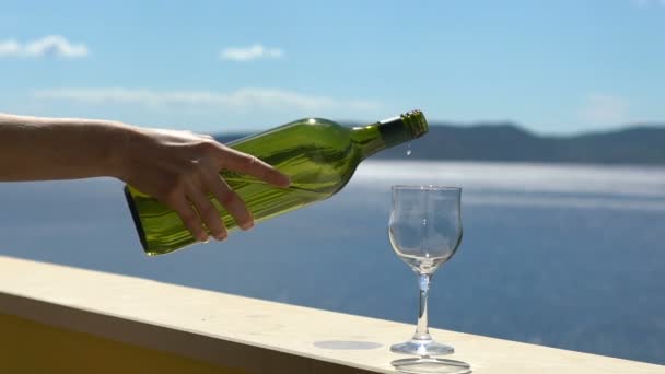 Vinho branco derramado, câmera lenta, mão feminina derrama vinho no mar — Vídeo de Stock